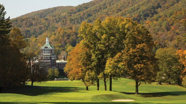 A large hotel is pictured with a golf course in the foreground