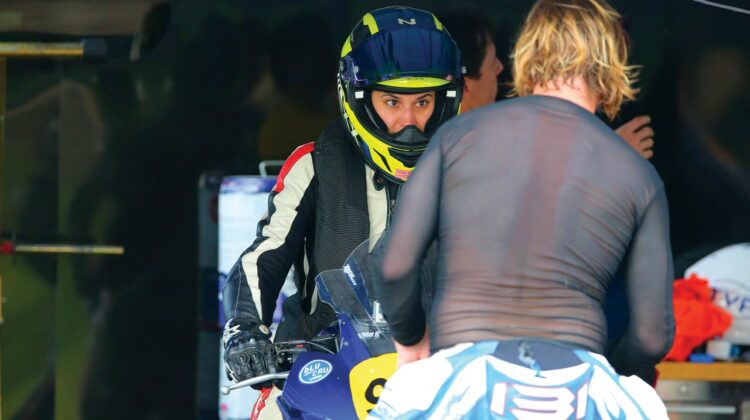 A woman on a motorcycle receives coaching