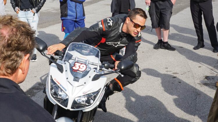 An instructor talks with a student on a motorcycle