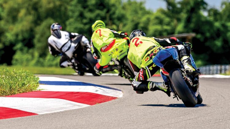 Motorcycle riders round a tight curve on a racetrack