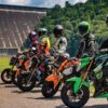 A group of motorcycle riders is parked in front of a dam