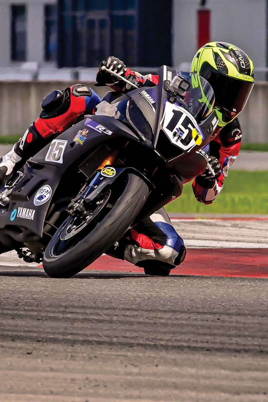 A motorcycle racer leans into a curve on a track.