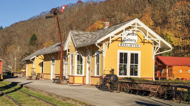 A historic train depot sits beside a disused railroad track