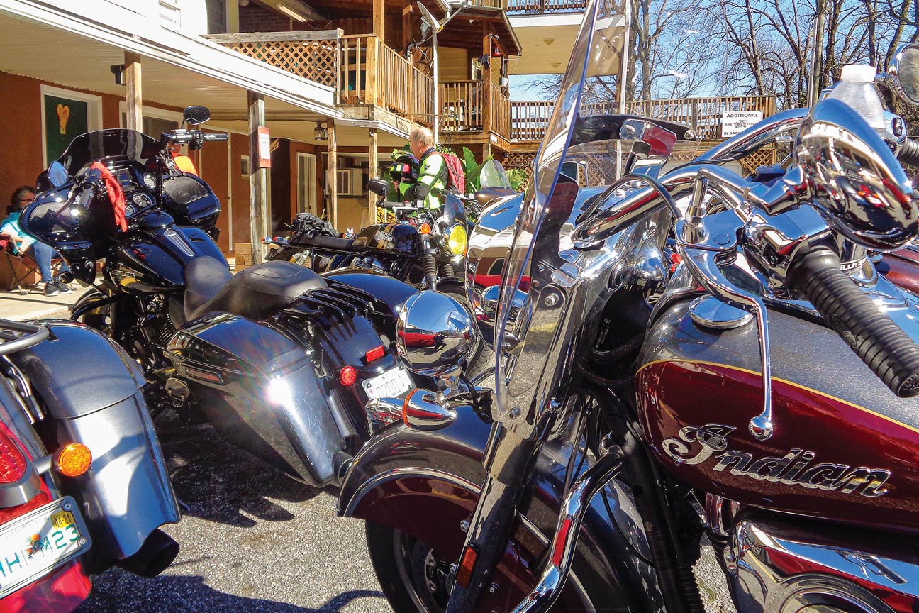 A group of motorcycles is parked outside of a bar