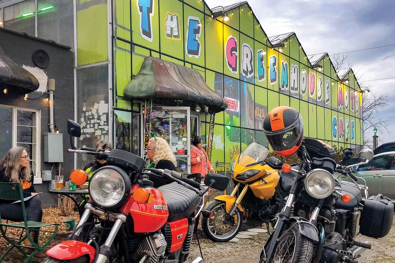 Motorcycles are parked in front of a brightly colored building