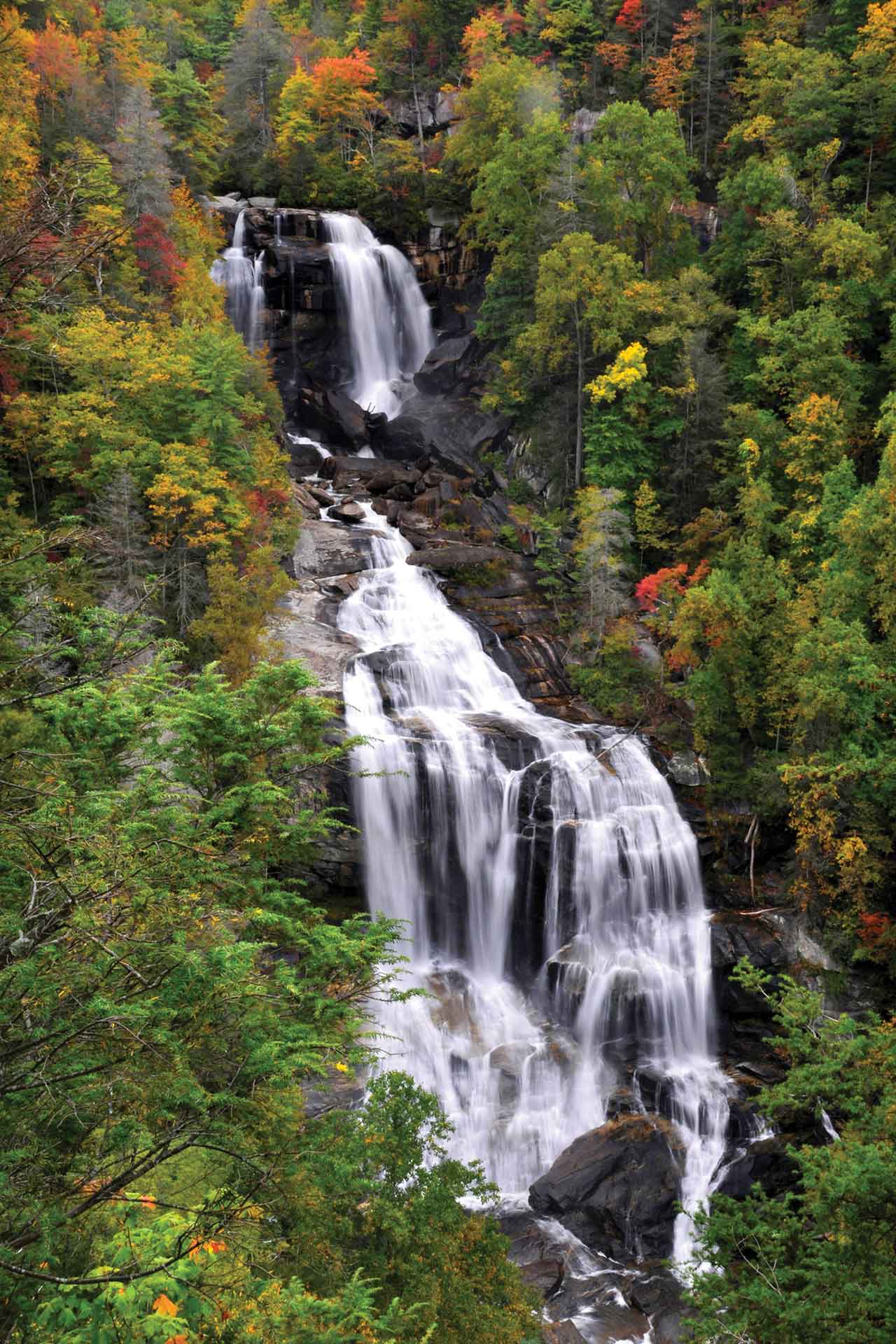 A distant shot of a waterfall cascading down a mountainside.