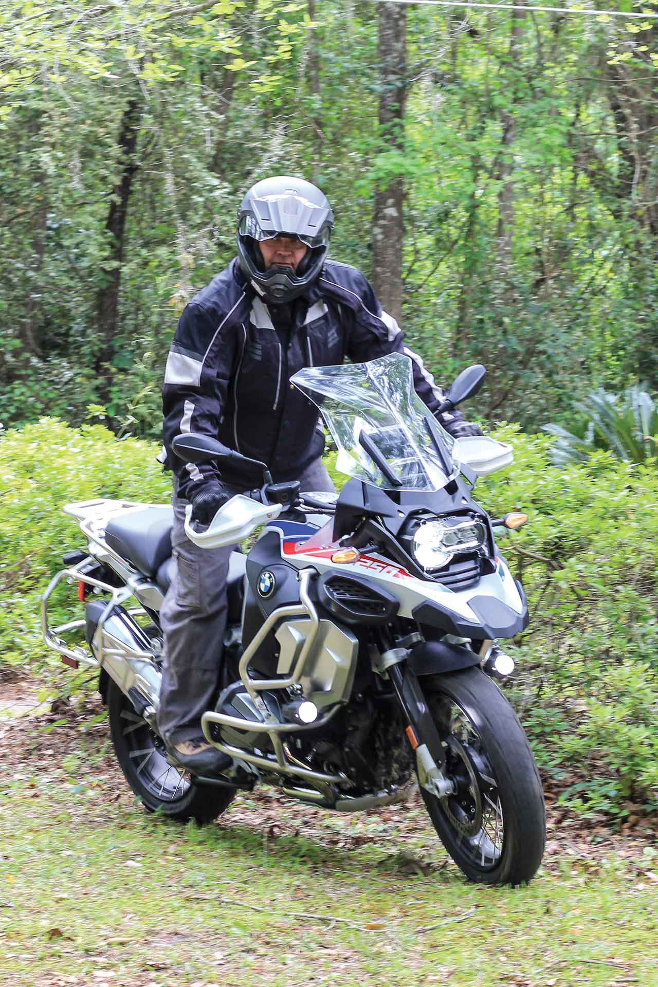 A motorcycle rides through grass.