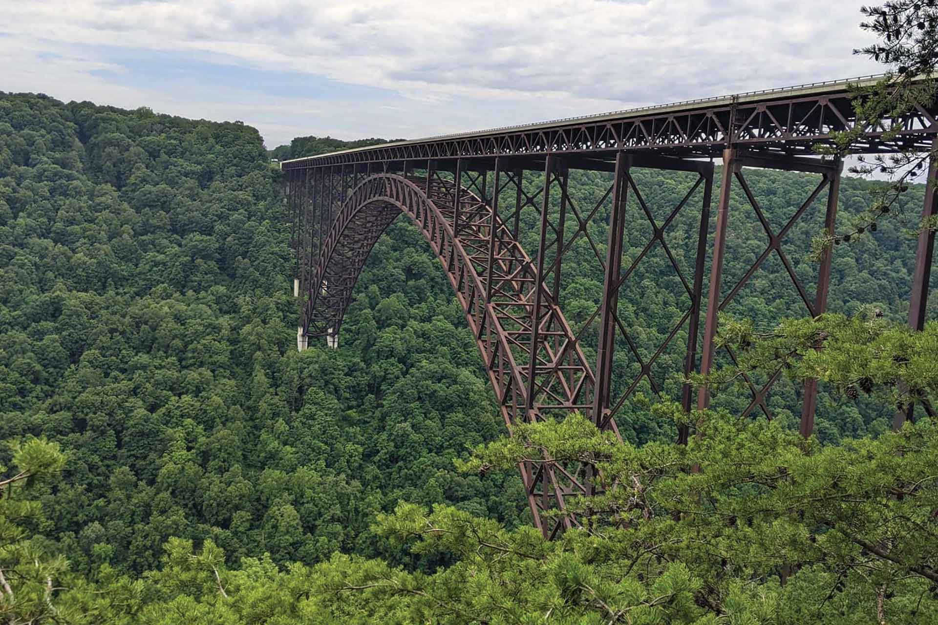 A large, iron arched bridge crosses the New River Gorge.
