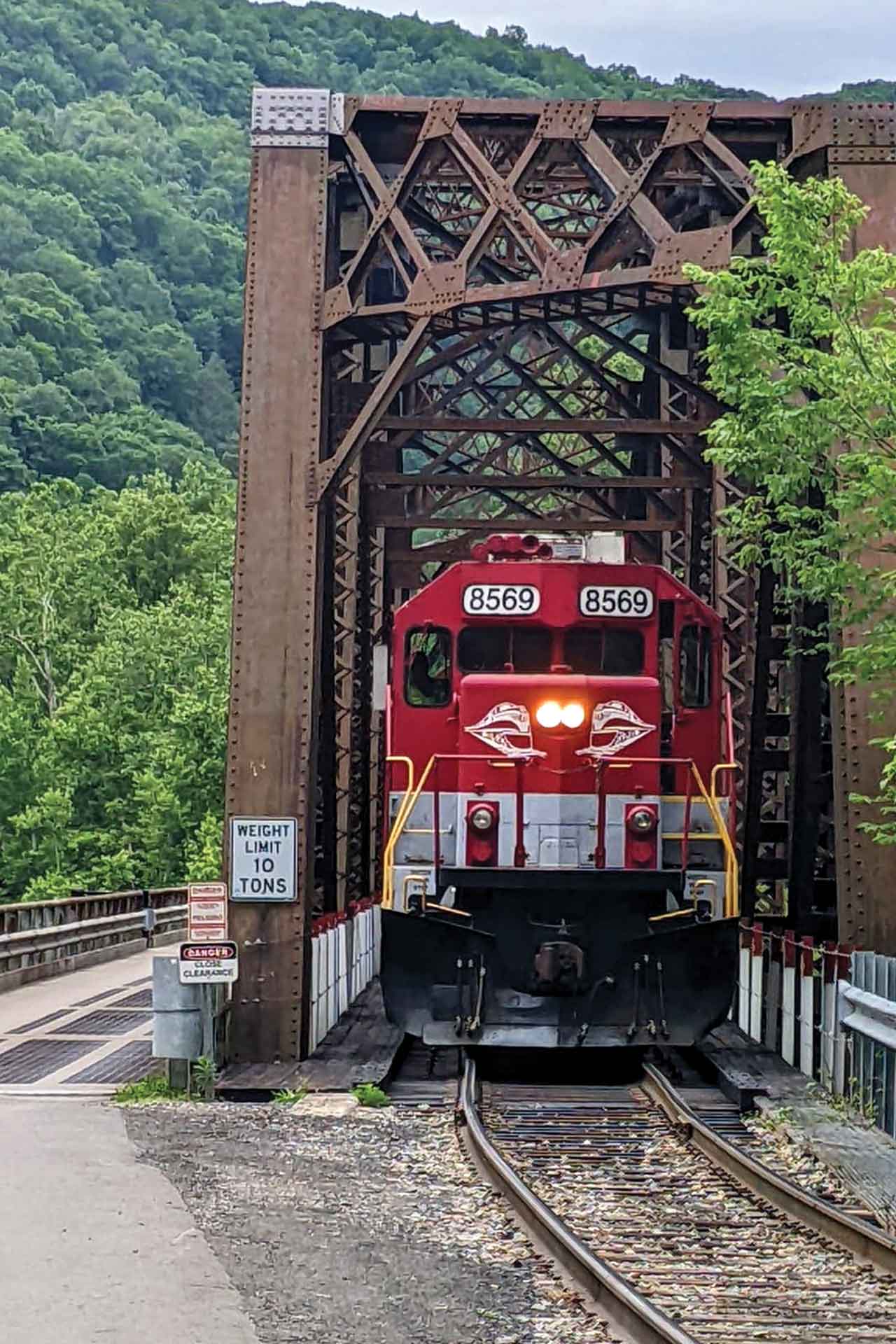 A train emerges from an iron bridge.