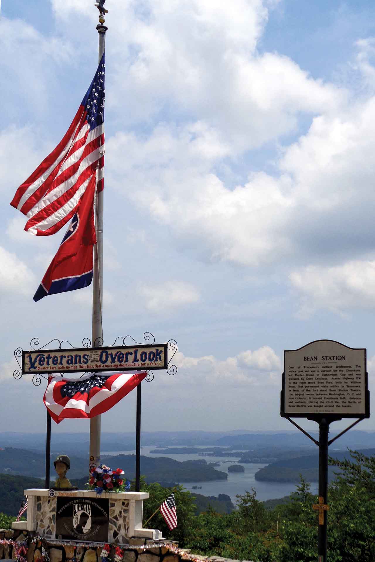 An overlook with a veterans memorial. A lake is in the background.