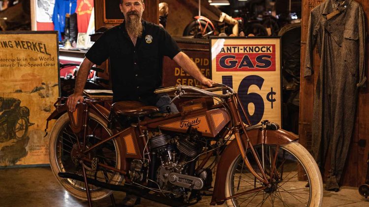 A man stands with a rare Traub motorcycle.