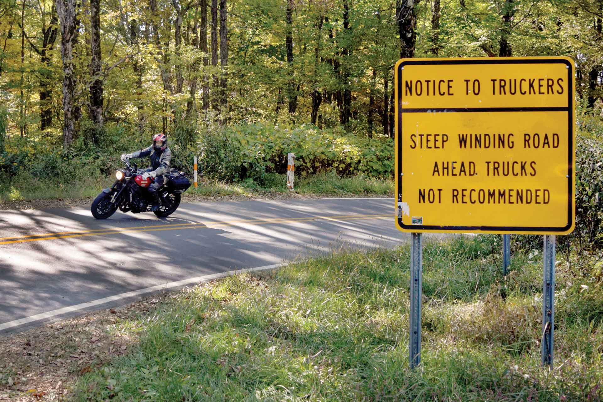A motorcycle rider navigates a steep, sharp curve