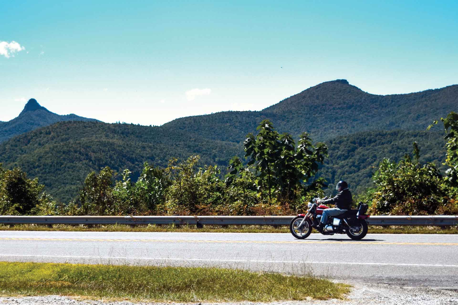 A panoramic photo of a motorcycle with Brown Mountain in the background